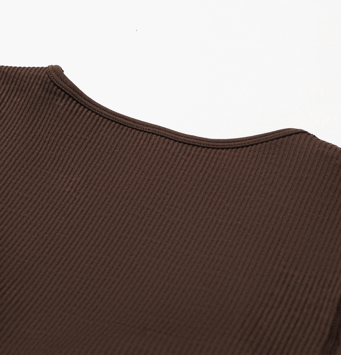 Close-up of brown seamless yoga suit fabric with fine ribbing, showcasing texture and quality suitable for women's fitness attire.